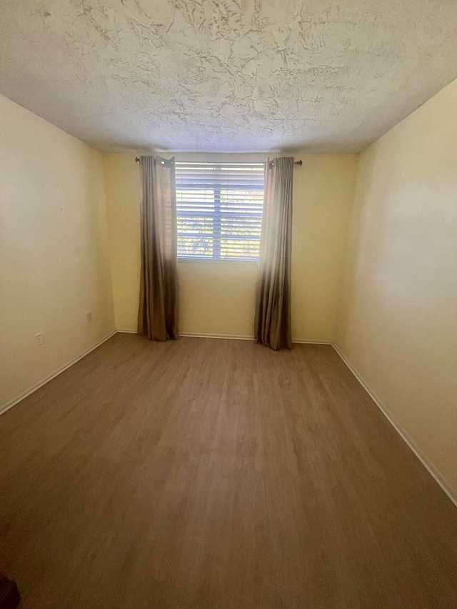 spare room featuring a textured ceiling and hardwood / wood-style flooring