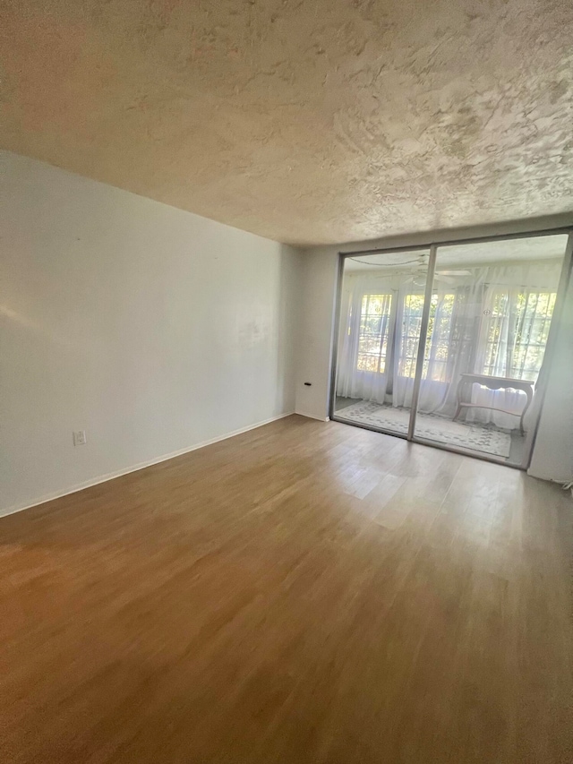 spare room featuring hardwood / wood-style floors and a textured ceiling