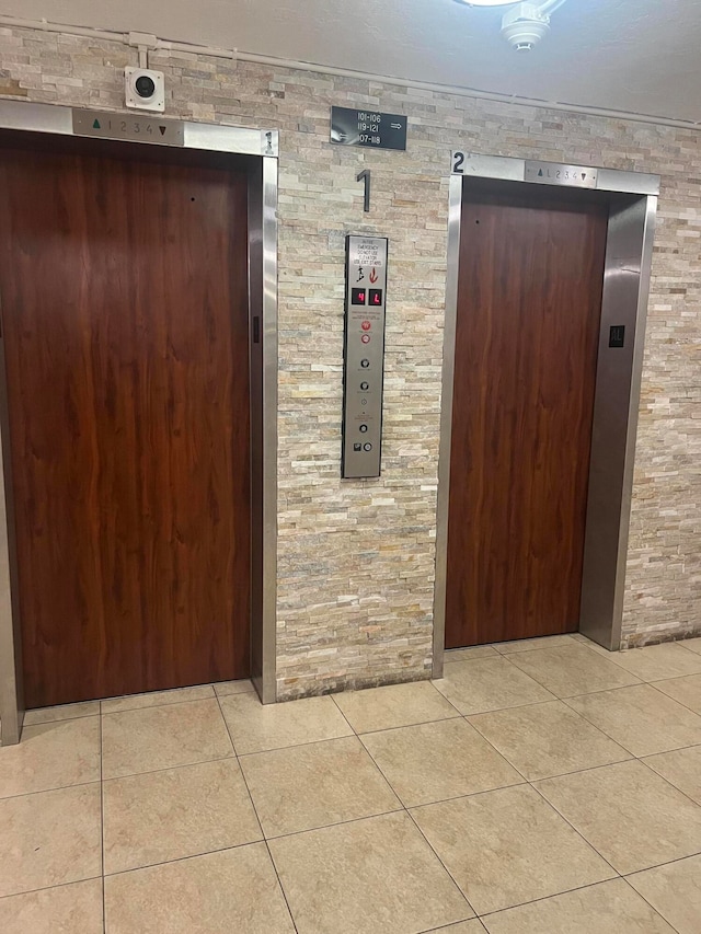 hall with elevator and light tile patterned floors