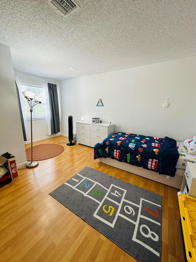 bedroom featuring hardwood / wood-style flooring and a textured ceiling