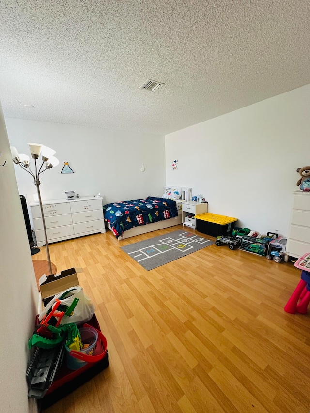 bedroom with wood-type flooring and a textured ceiling