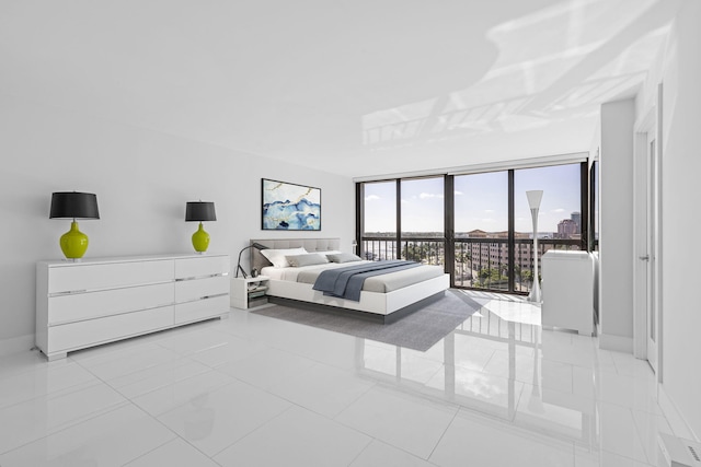 bedroom featuring access to outside, a wall of windows, and light tile patterned floors