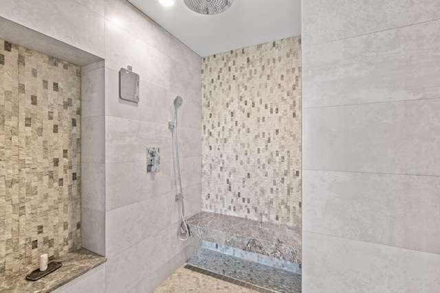 bathroom featuring tile walls and a tile shower