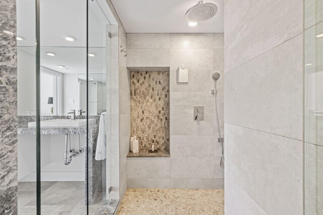 bathroom with vanity, an enclosed shower, and tile walls