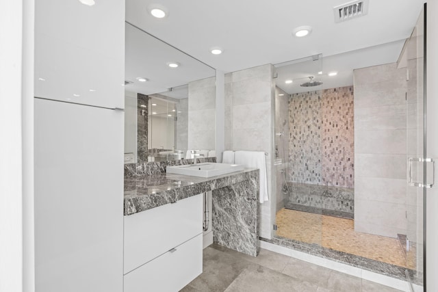 bathroom with tile walls, walk in shower, and vanity