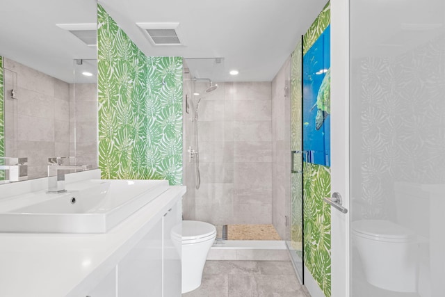 bathroom featuring a shower with door, vanity, toilet, and tile patterned flooring