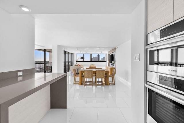 kitchen featuring light tile patterned flooring, rail lighting, and stainless steel double oven