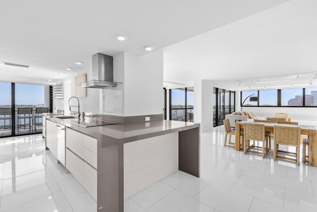 kitchen with white cabinets, sink, wall chimney exhaust hood, and plenty of natural light