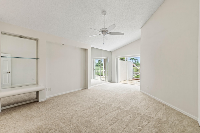 carpeted spare room with ceiling fan, a textured ceiling, and vaulted ceiling