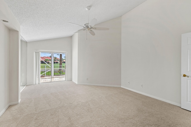 empty room with ceiling fan, a textured ceiling, lofted ceiling, and light colored carpet