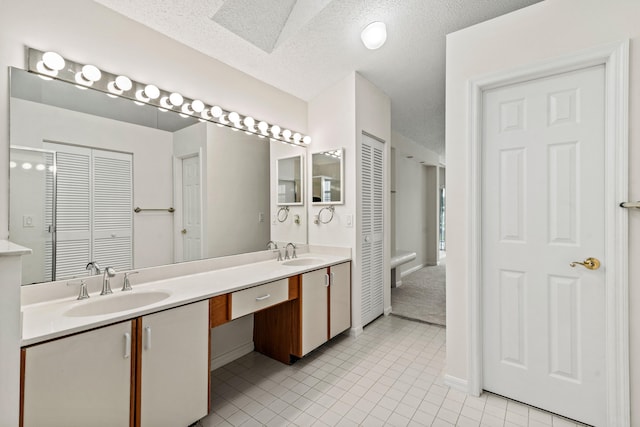 bathroom with vanity, a textured ceiling, and tile patterned floors