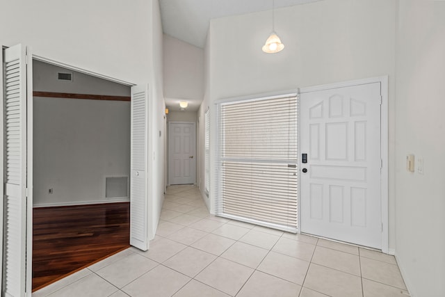 foyer entrance with a high ceiling and light hardwood / wood-style flooring