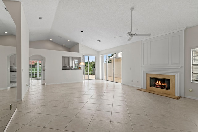 unfurnished living room with ceiling fan, a textured ceiling, light tile patterned floors, and high vaulted ceiling