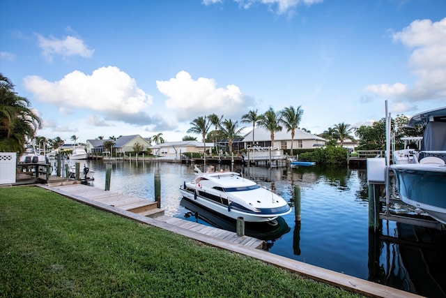 view of dock with a water view and a lawn