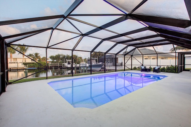 outdoor pool featuring a lanai, a water view, and a patio