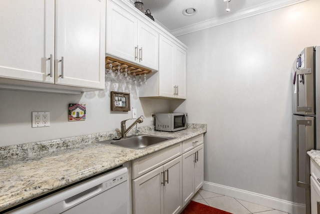 kitchen with appliances with stainless steel finishes, ornamental molding, sink, light tile patterned floors, and white cabinets