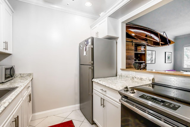 kitchen featuring white cabinets, crown molding, light tile patterned flooring, light stone counters, and stainless steel appliances