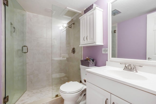 bathroom with a shower with door, vanity, and toilet