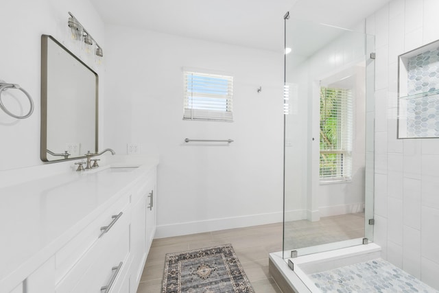 bathroom with hardwood / wood-style floors, vanity, and a shower with door