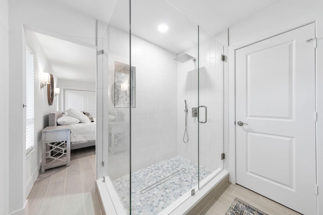 bathroom with wood-type flooring and a shower with shower door