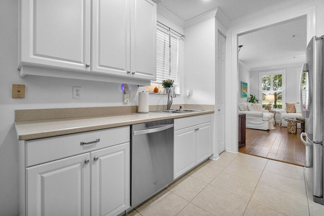 kitchen with stainless steel appliances, white cabinetry, sink, ornamental molding, and light hardwood / wood-style flooring