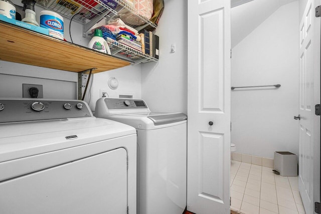 laundry area featuring washing machine and clothes dryer and light tile patterned floors