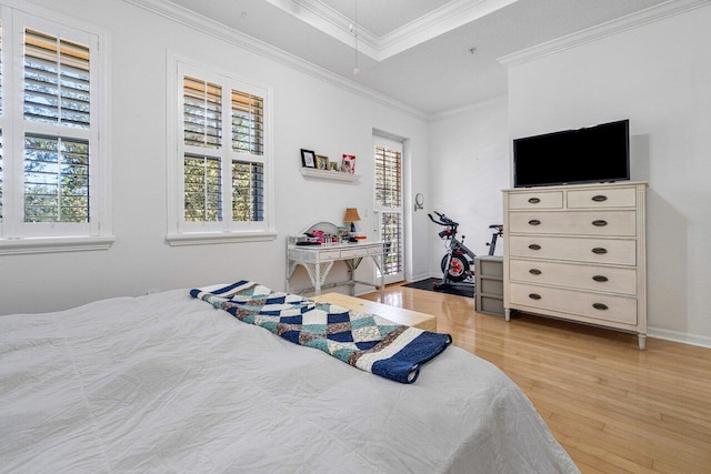 bedroom with ornamental molding, multiple windows, and light hardwood / wood-style floors