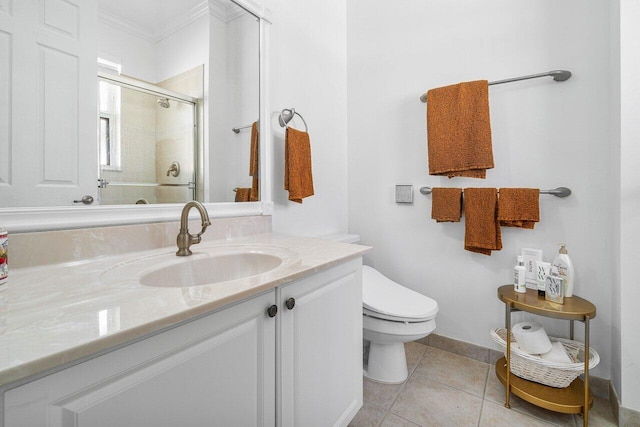 bathroom featuring toilet, tile patterned floors, a shower with door, vanity, and crown molding