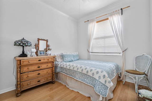 bedroom featuring ceiling fan, light hardwood / wood-style floors, and crown molding