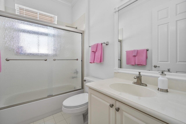 full bathroom featuring tile patterned flooring, ornamental molding, enclosed tub / shower combo, vanity, and toilet