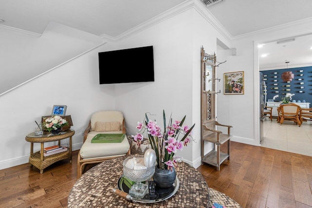 sitting room featuring ornamental molding, hardwood / wood-style floors, and a textured ceiling