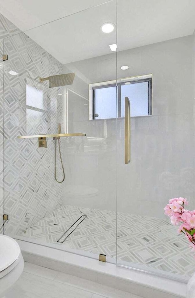 bathroom featuring tile patterned flooring, toilet, and walk in shower