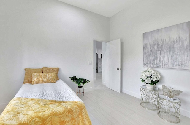 bedroom featuring a towering ceiling and wood-type flooring