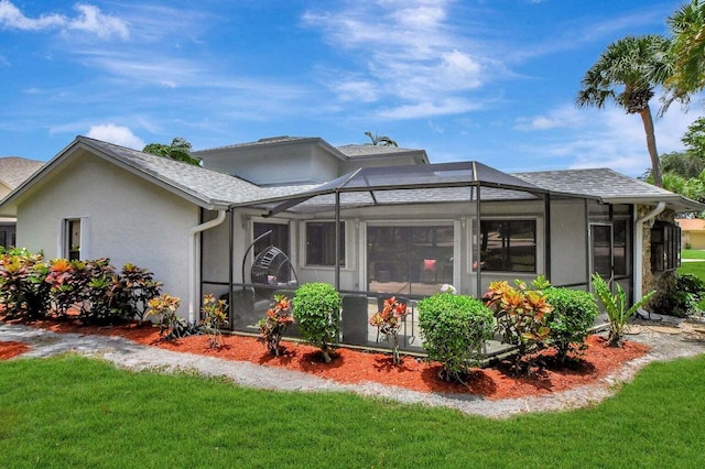 view of front of house featuring a front yard and glass enclosure