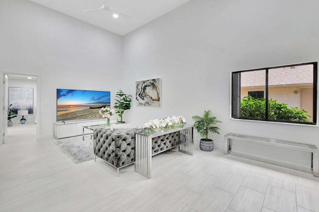 living room with a high ceiling and ceiling fan