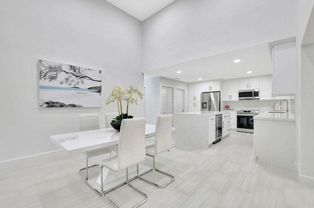 dining room with sink, wine cooler, and a high ceiling