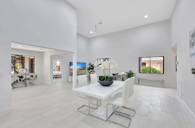 dining room with a towering ceiling and a healthy amount of sunlight