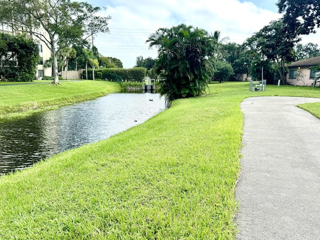 view of property's community featuring a yard and a water view