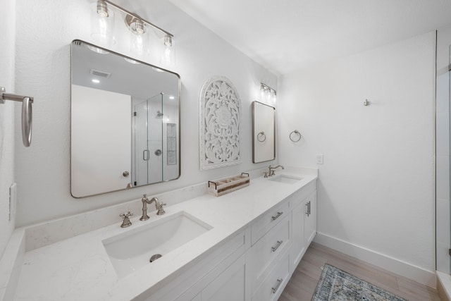 bathroom featuring hardwood / wood-style floors, vanity, and walk in shower