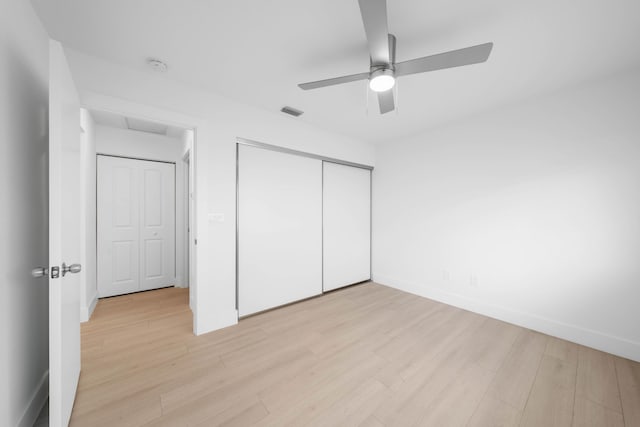 unfurnished bedroom featuring a closet, light hardwood / wood-style floors, and ceiling fan