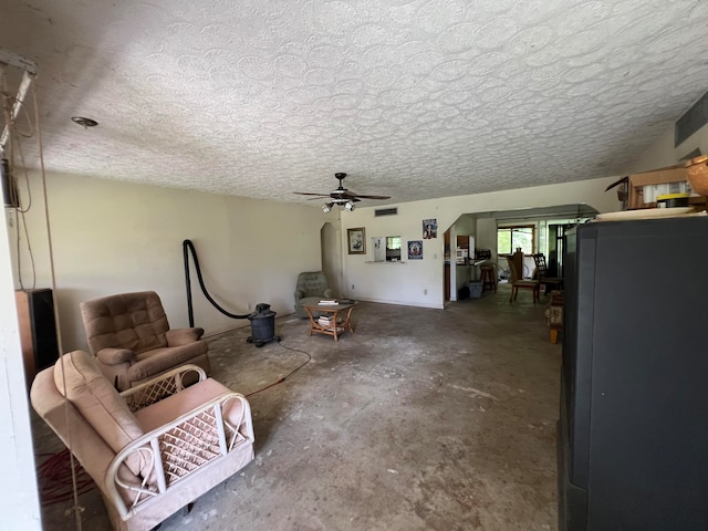 interior space with ceiling fan, concrete flooring, and a textured ceiling