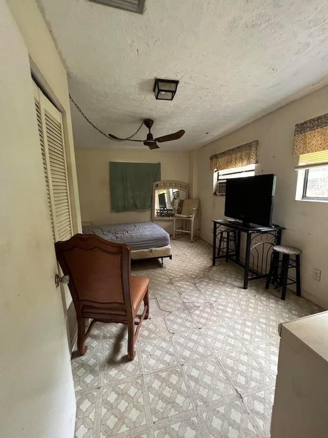 bedroom with ceiling fan, a closet, and a textured ceiling