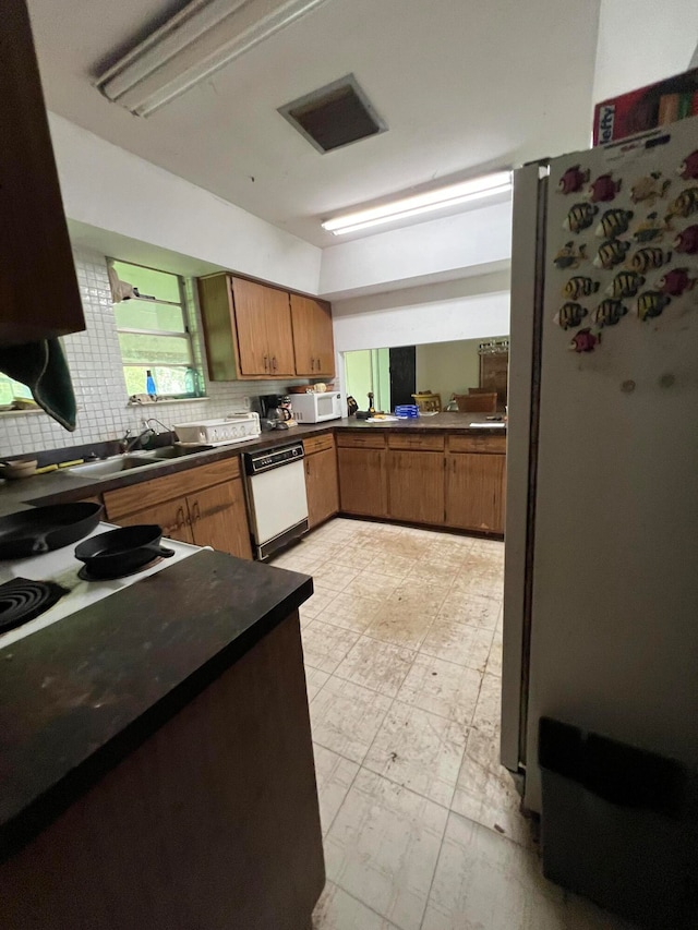 kitchen featuring tasteful backsplash, sink, and white appliances