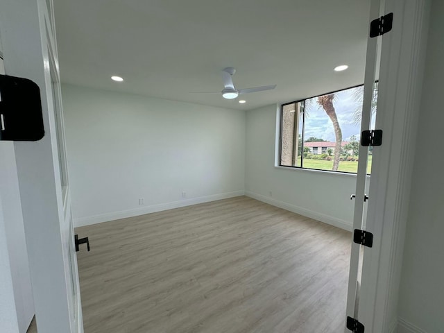 spare room with light wood-type flooring and ceiling fan