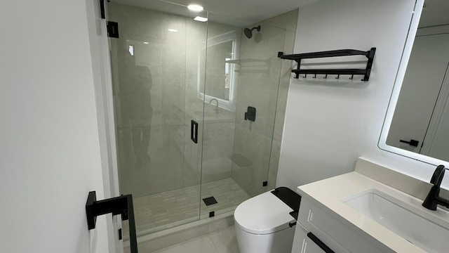 bathroom featuring toilet, a shower with shower door, vanity, and tile patterned flooring