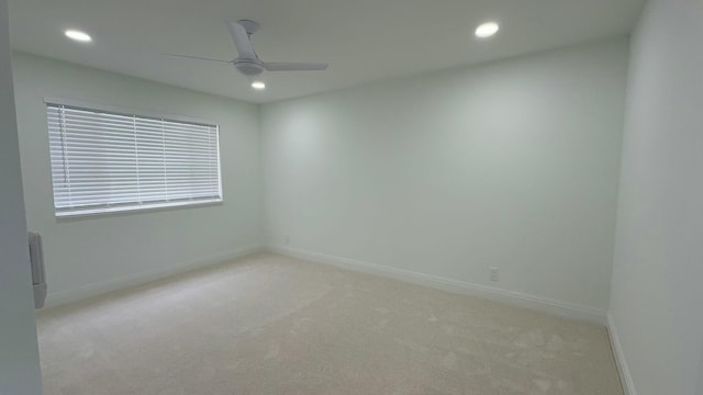 spare room featuring light carpet and ceiling fan