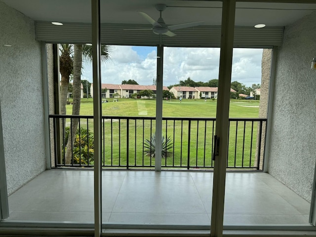 unfurnished sunroom with ceiling fan