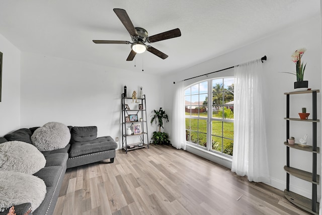 sitting room featuring light hardwood / wood-style floors, ceiling fan, and a textured ceiling