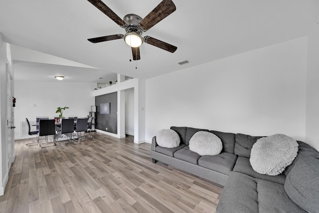 living room with ceiling fan, light wood-type flooring, and vaulted ceiling