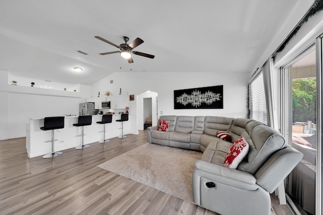 living room with lofted ceiling, hardwood / wood-style flooring, and ceiling fan